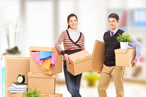 Professional removals crew unloading boxes and furniture at a Gunnersbury property